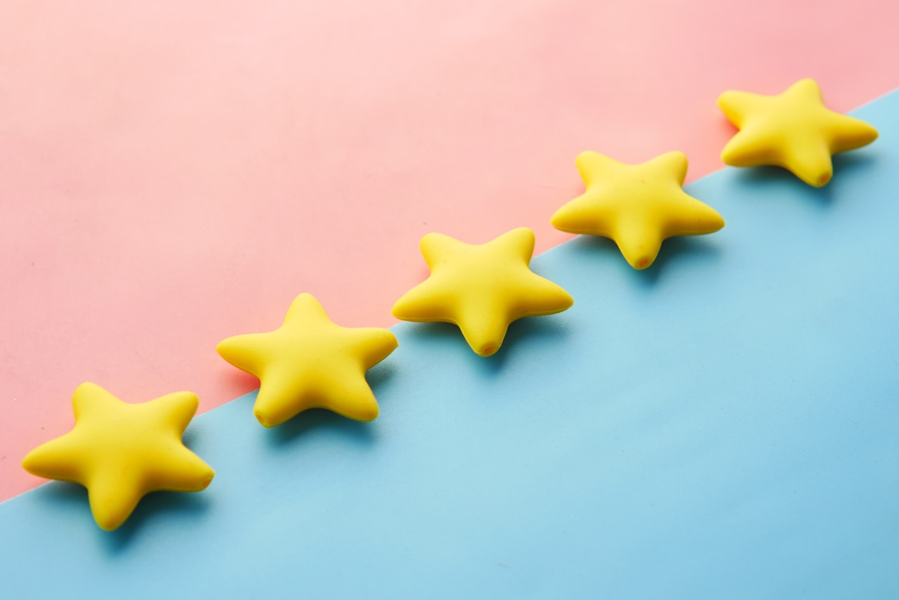 Five stars on a pastel pink and blue background